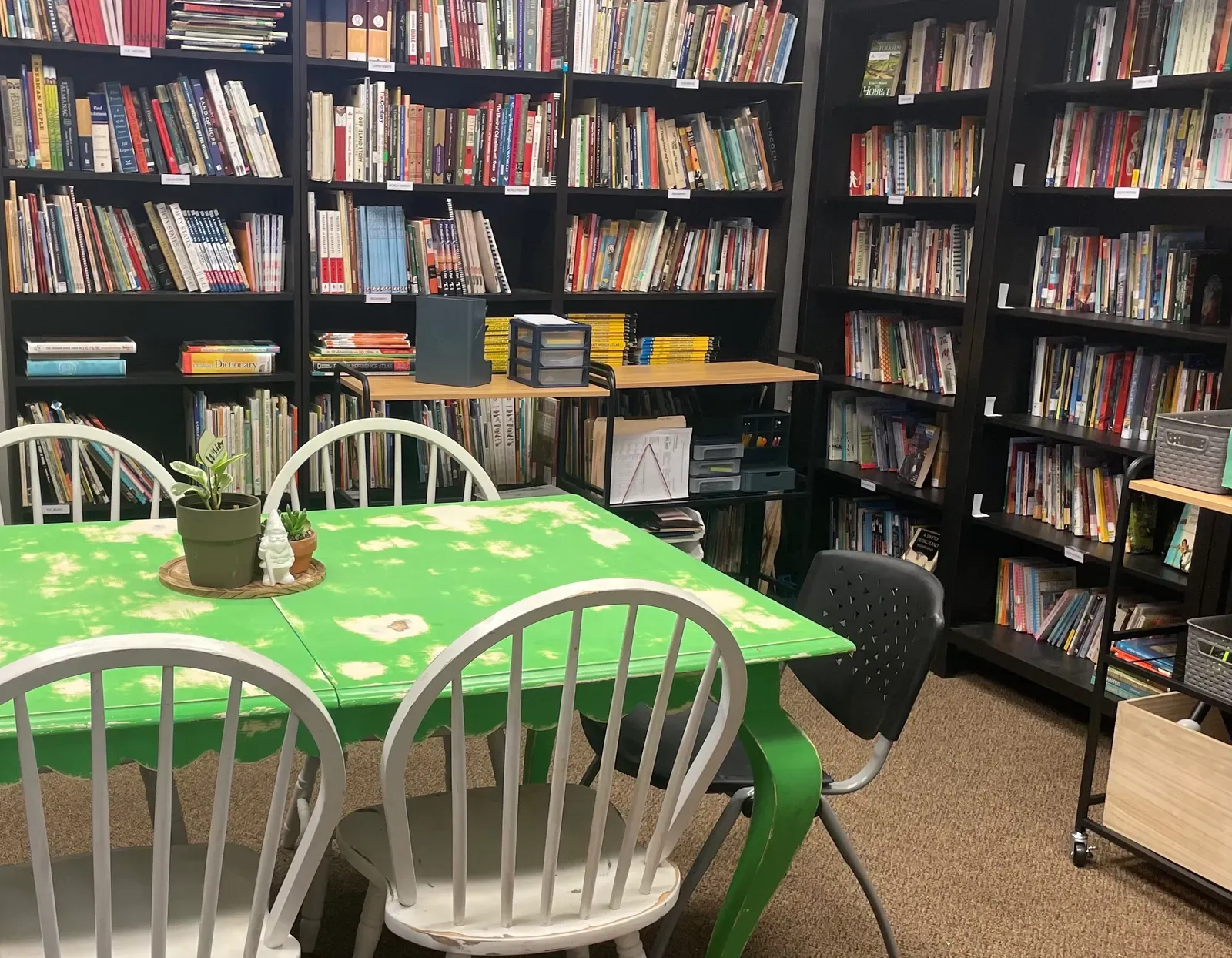 The Cimarron library: shelves of living books around a green work table